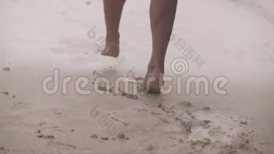 穿着<strong>泳装</strong>留长发的时髦女孩赤脚走在热带的沙岩海滩上